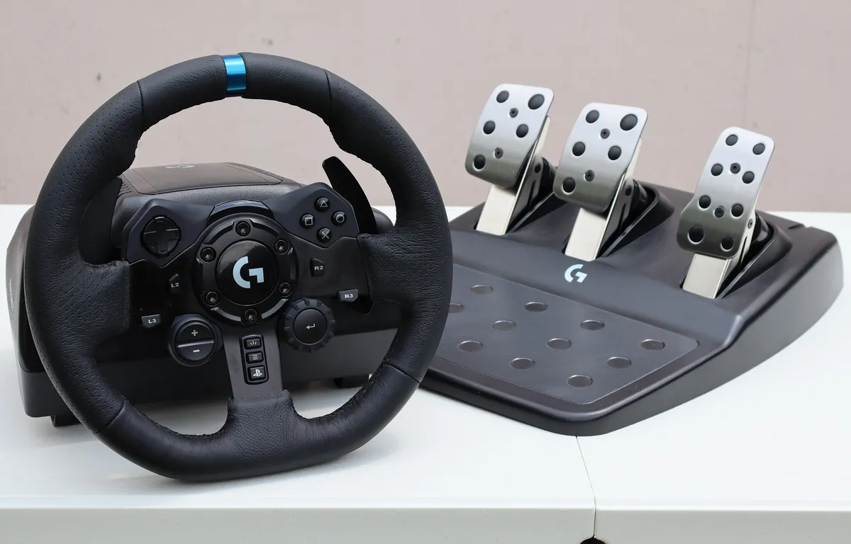Logitech G923 racing wheel and three-pedal set, PlayStation version, on a white table